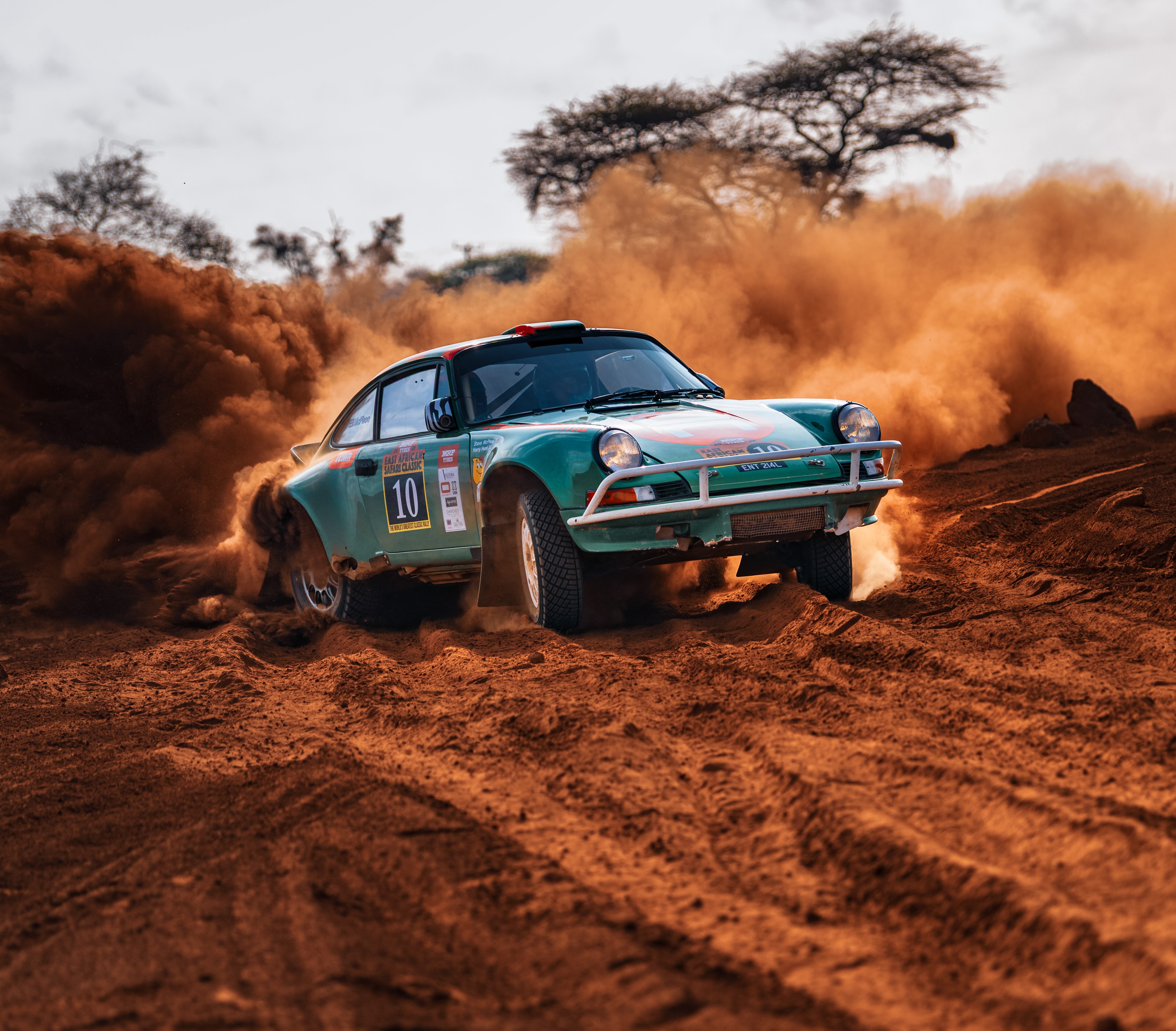 A Tuthill Porsche 911 Safari car kicks up dust in Kenya at the East African Safari Rally